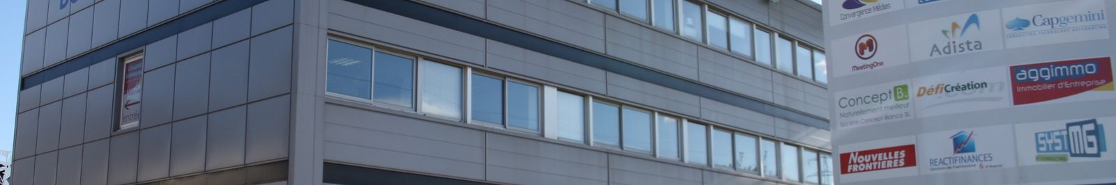 Façade du centre Espace Entreprise Millénaire et totem affichant les entreprises hébergées sur le site